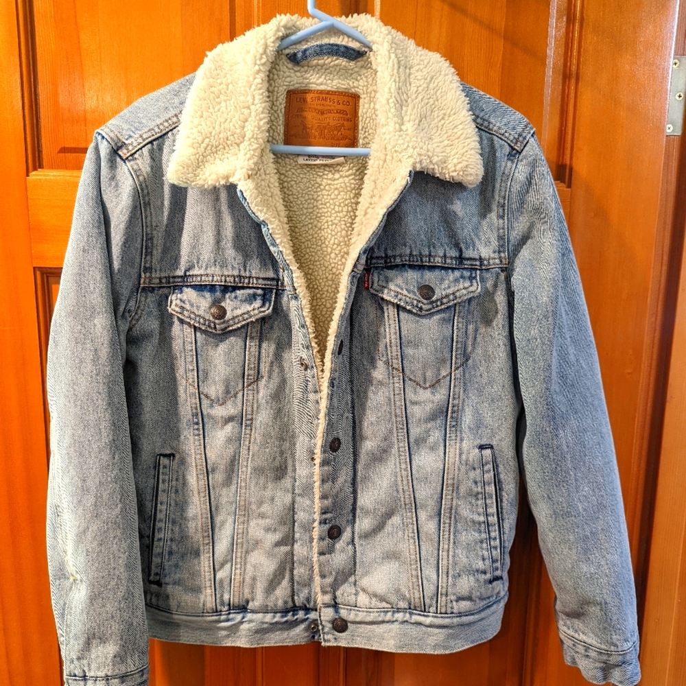 A fleece lined Levis denim trucker jacket with pockets, snap front.
